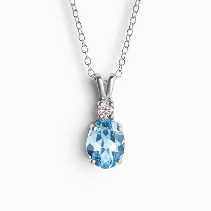 Silver necklace with a blue topaz gemstone pendant on a white background