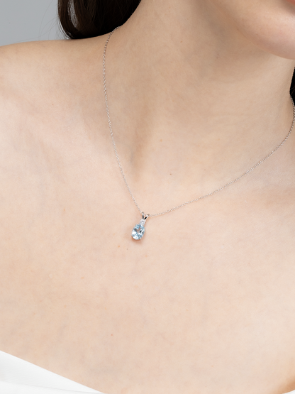 Necklace with a blue topaz gemstone pendant on a plain background