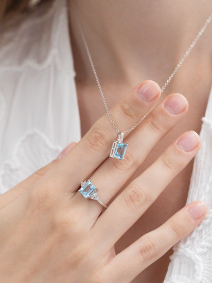 Silver jewellery set with blue topaz gemstones on a hand