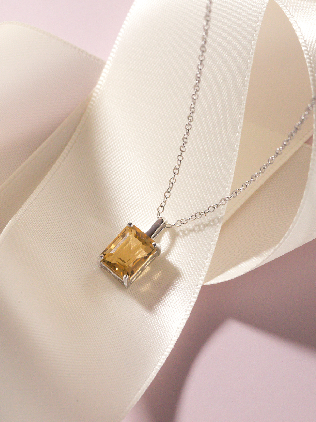 Yellow citrine gemstone necklace on a soft fabric background