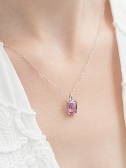 Necklace with a purple amethyst gemstone pendant on a blurred background