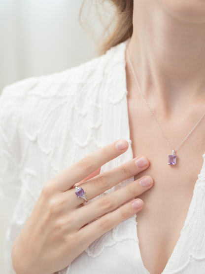Women wearing a necklace and ring with purple amethyst gemstones on a white background