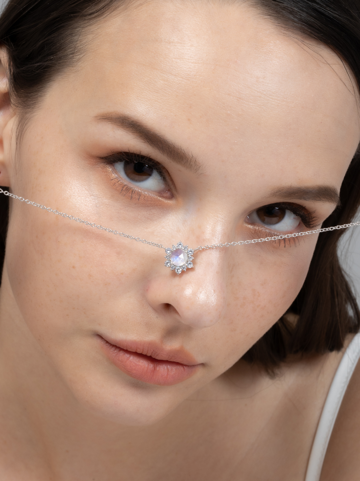 Woman wearing a delicate silver chain with a moonstone gemstone.