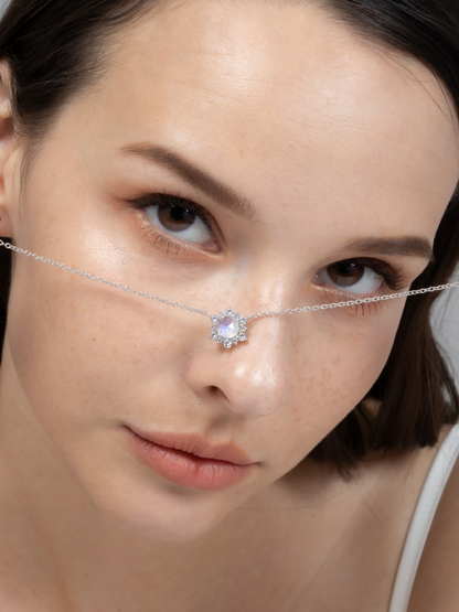 Woman wearing a delicate silver chain with a moonstone gemstone.