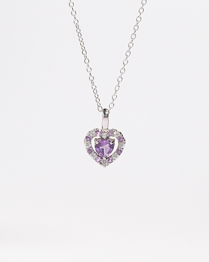 Heart-shaped purple amethyst gemstone pendant on a chain against a white background
