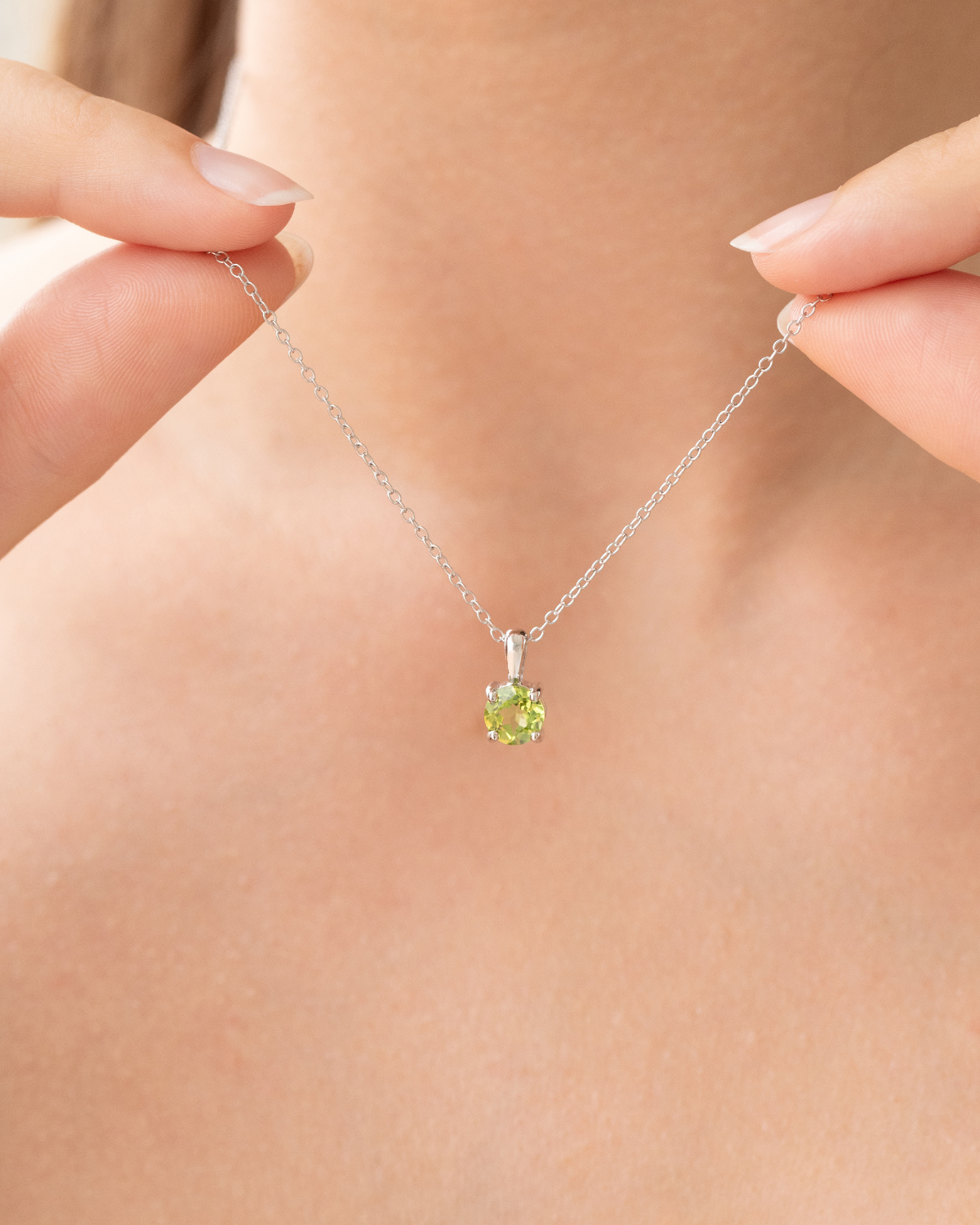 Peridot necklace on a person's neck with a blurred background