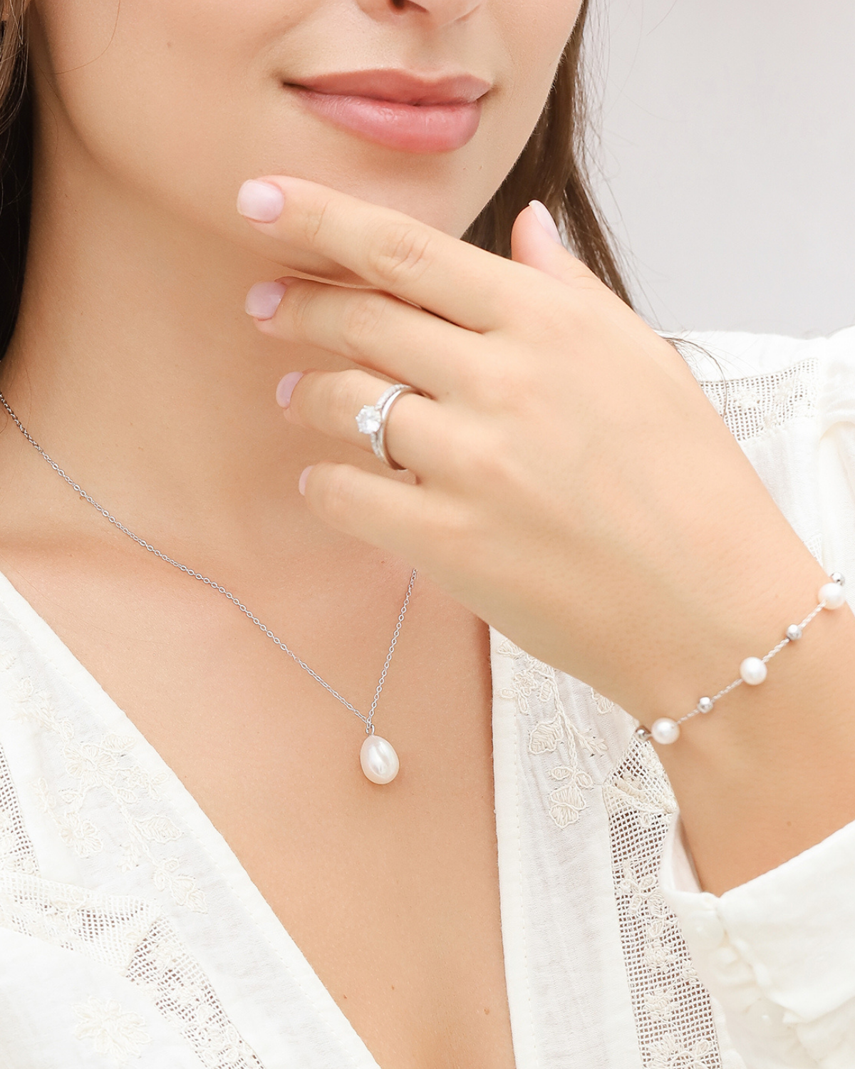 Woman wearing a pearl necklace, bracelet, and ring