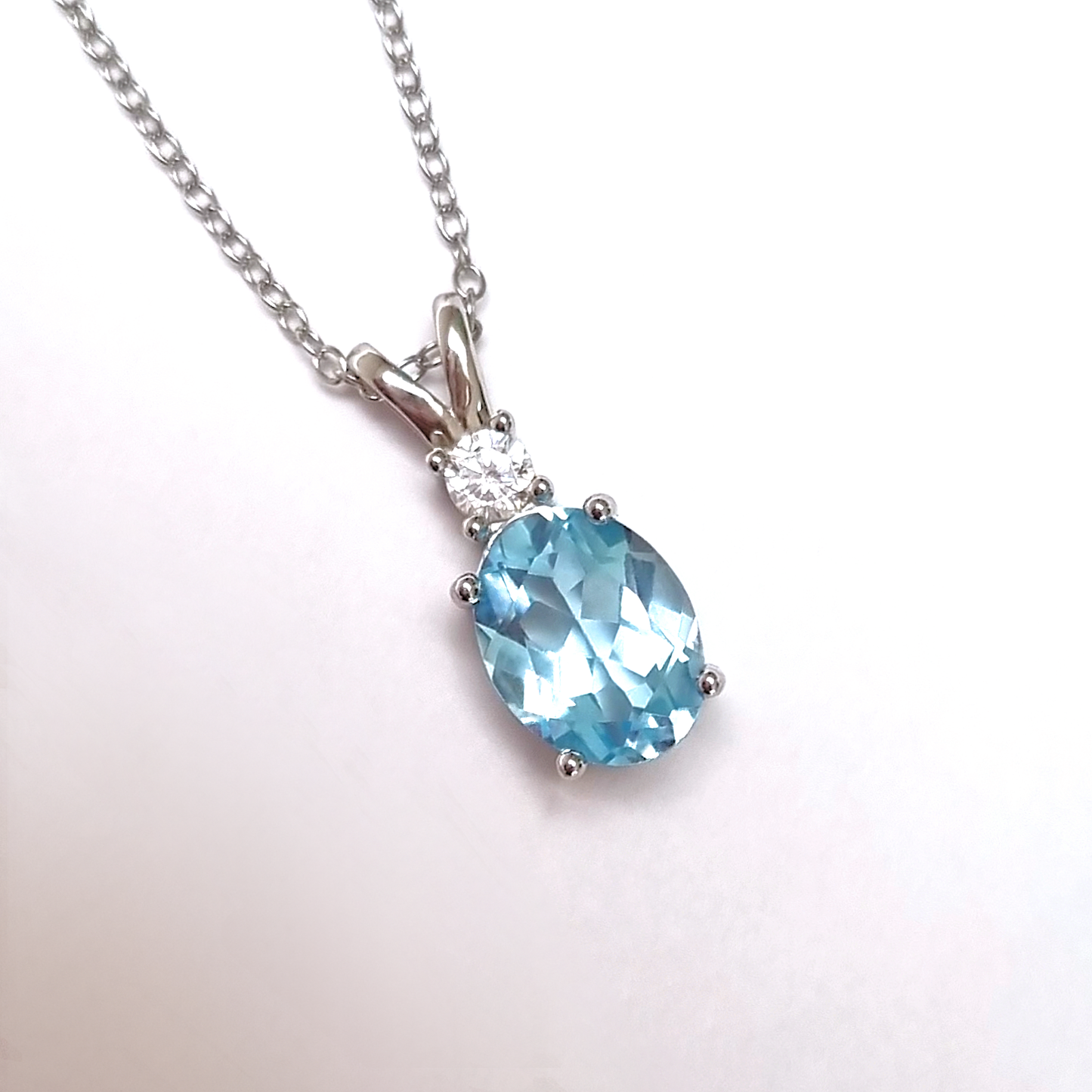 Necklace with a blue topaz gemstone pendant on a white background