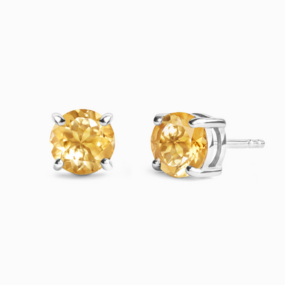 Pair of yellow citrine gemstone stud earrings on a white background