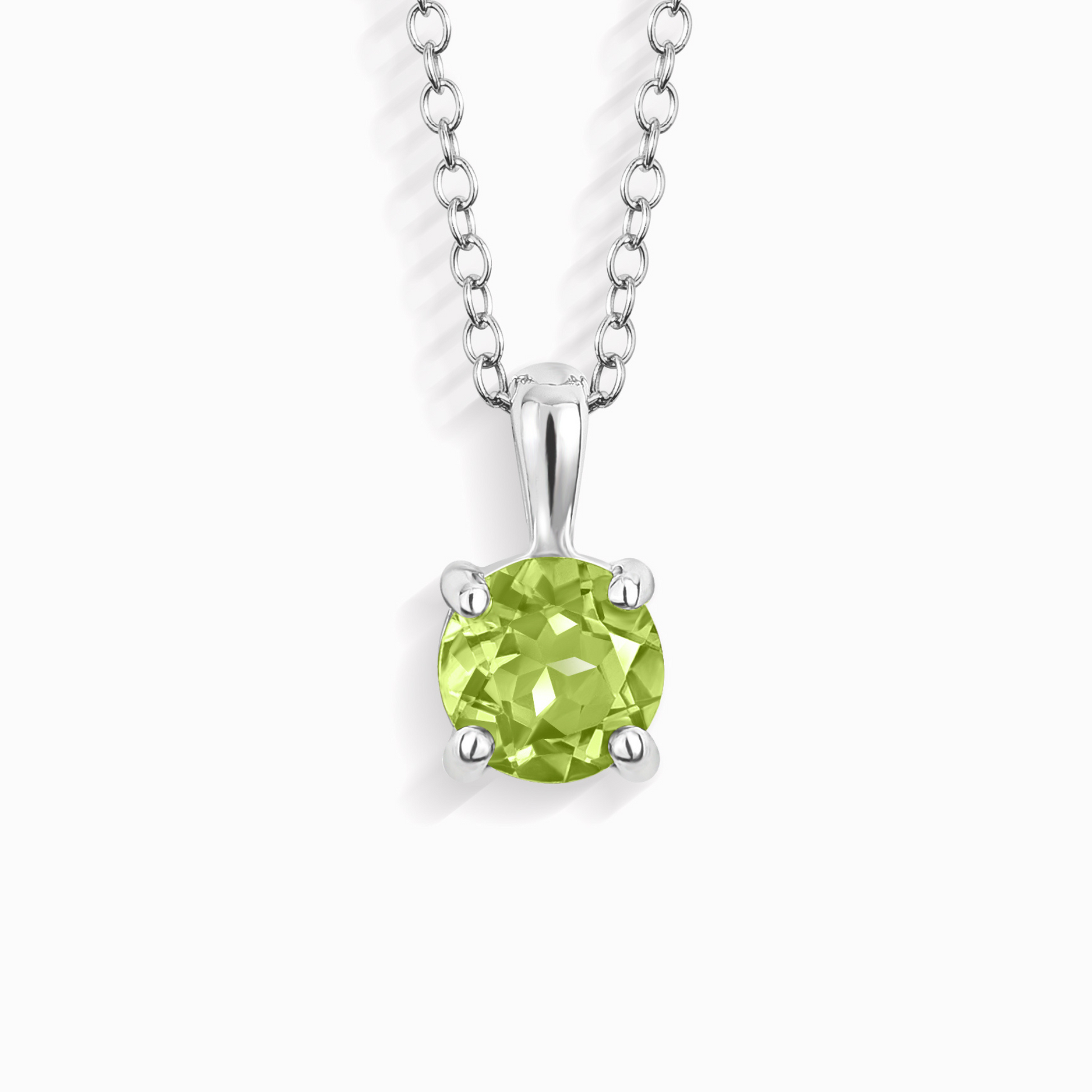 Green peridot gemstone pendant on a silver chain against a white background