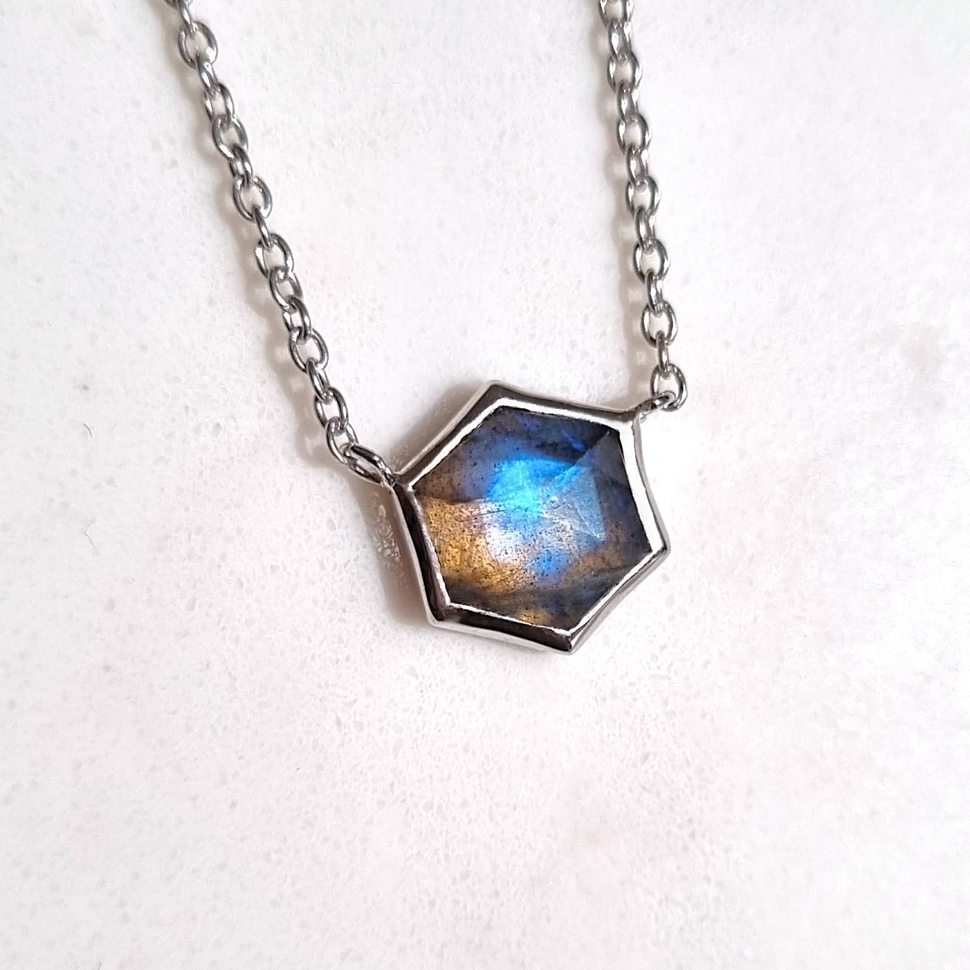 Labradorite Necklace with a hexagonal pendant featuring a blue and gold hue on a white background