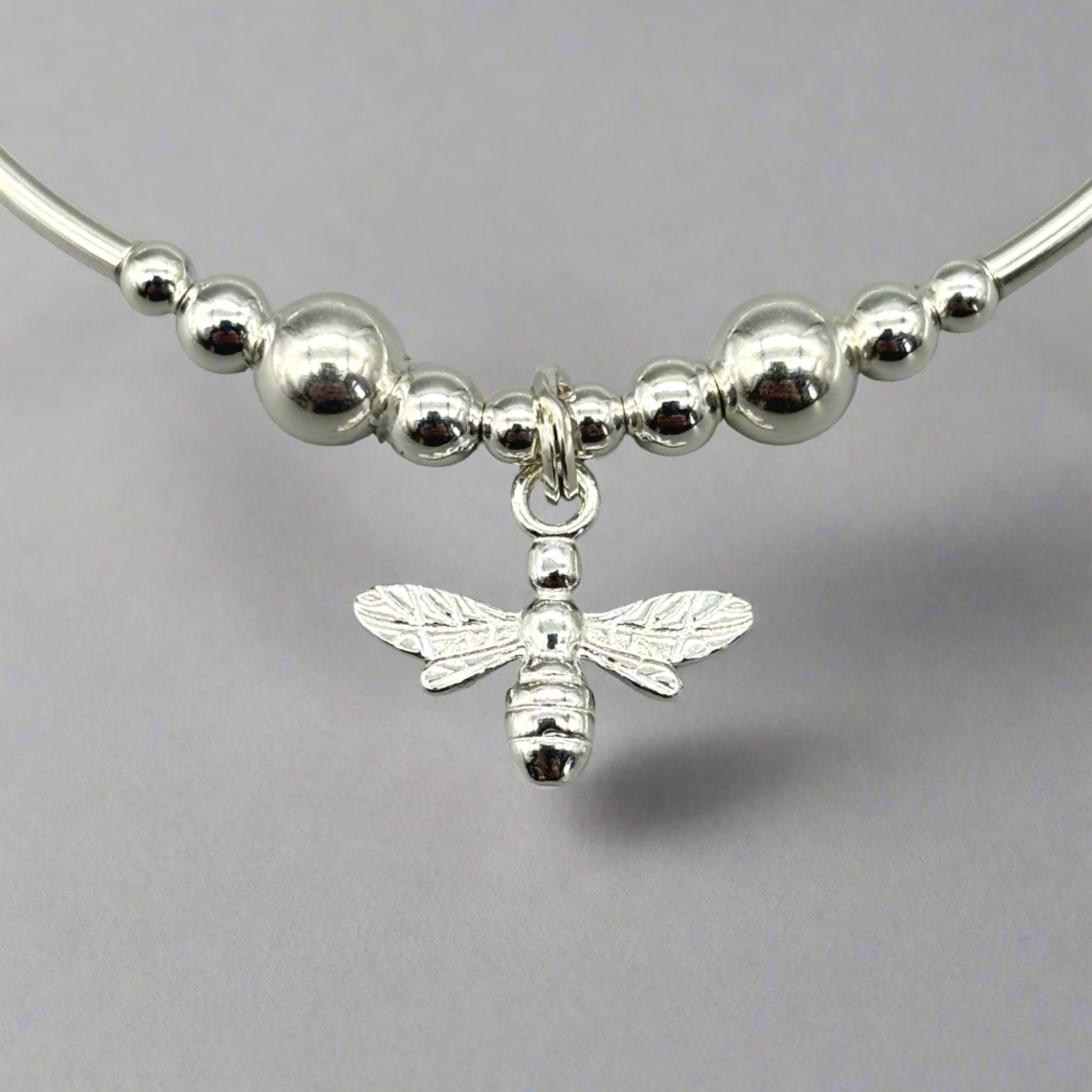 Closeup of bee charm sterling silver stacking stretch bracelet for her by My Silver Wish
