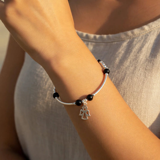 Model wearing a Angel charm black onyx gemstone women's sterling silver stacking bracelet by My Silver Wish