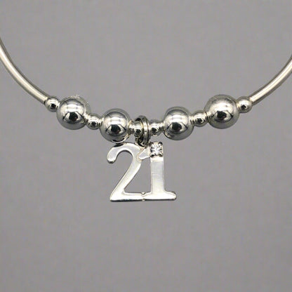 Closeup of 21st Birthday charm women's sterling silver stacking bracelet by My Silver Wish