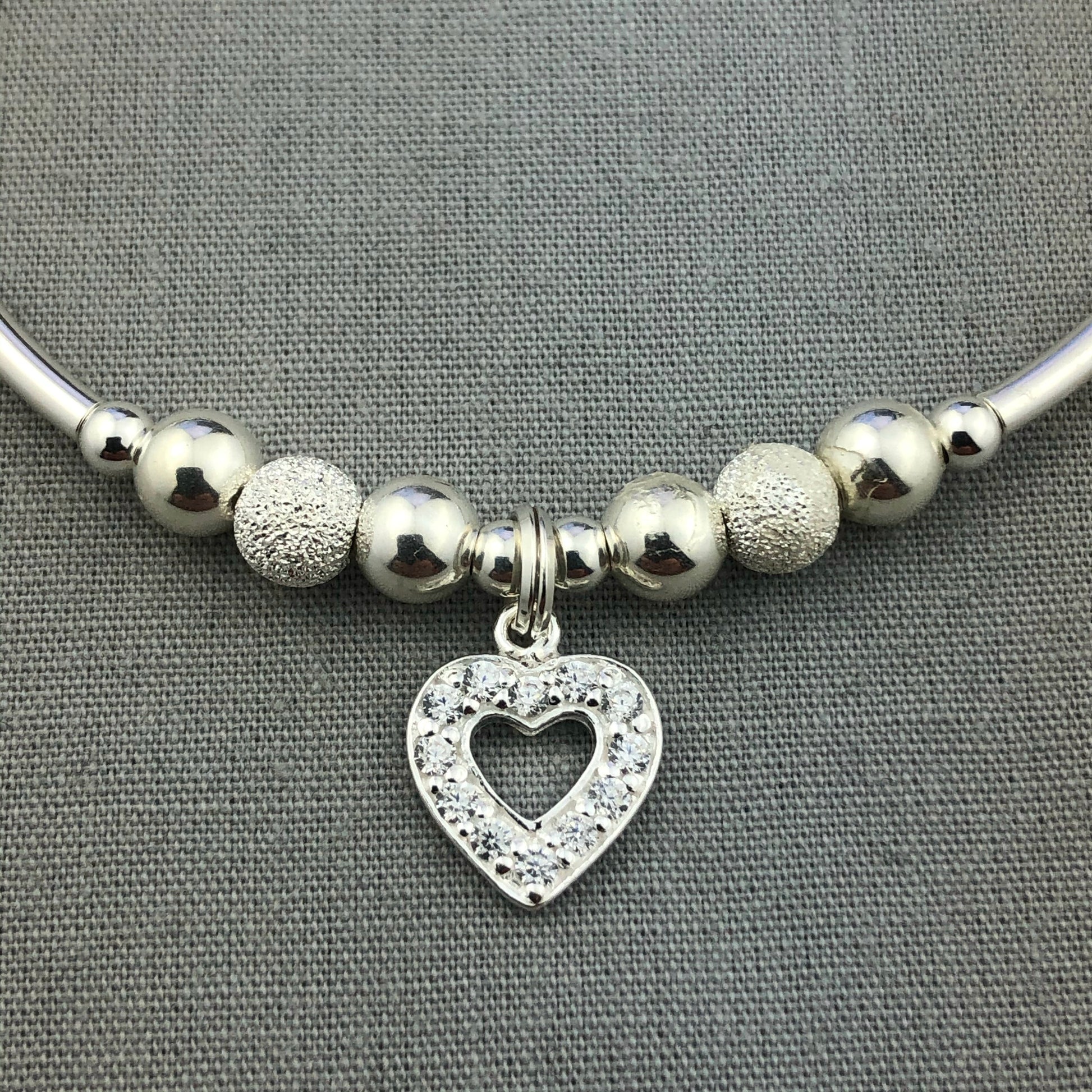 Closeup of Crystal heart charm sterling silver stacking charm bracelet by My Silver Wish