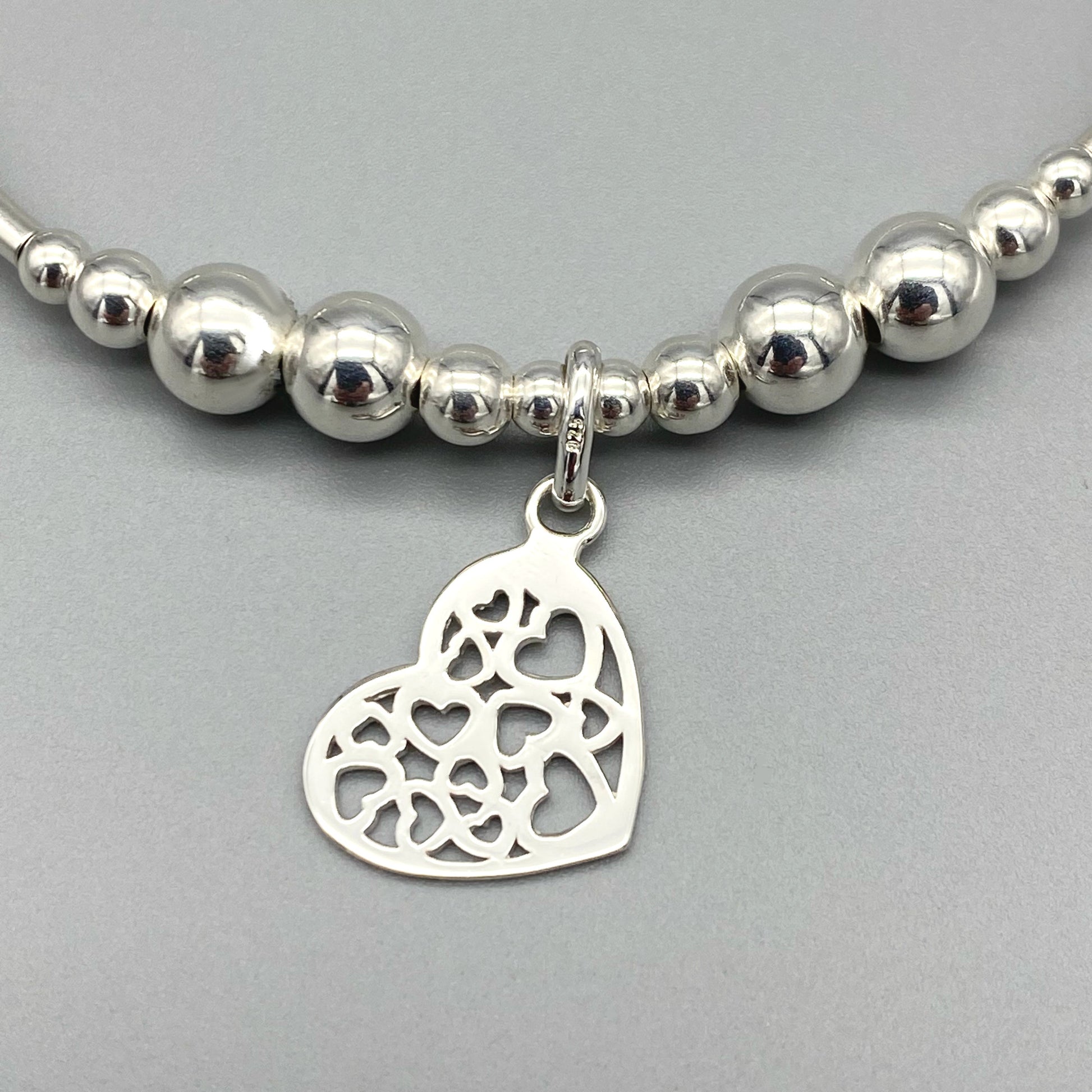 Closeup of Heart charm filigree sterling silver hand-made women's stacking bracelet by My Silver Wish
