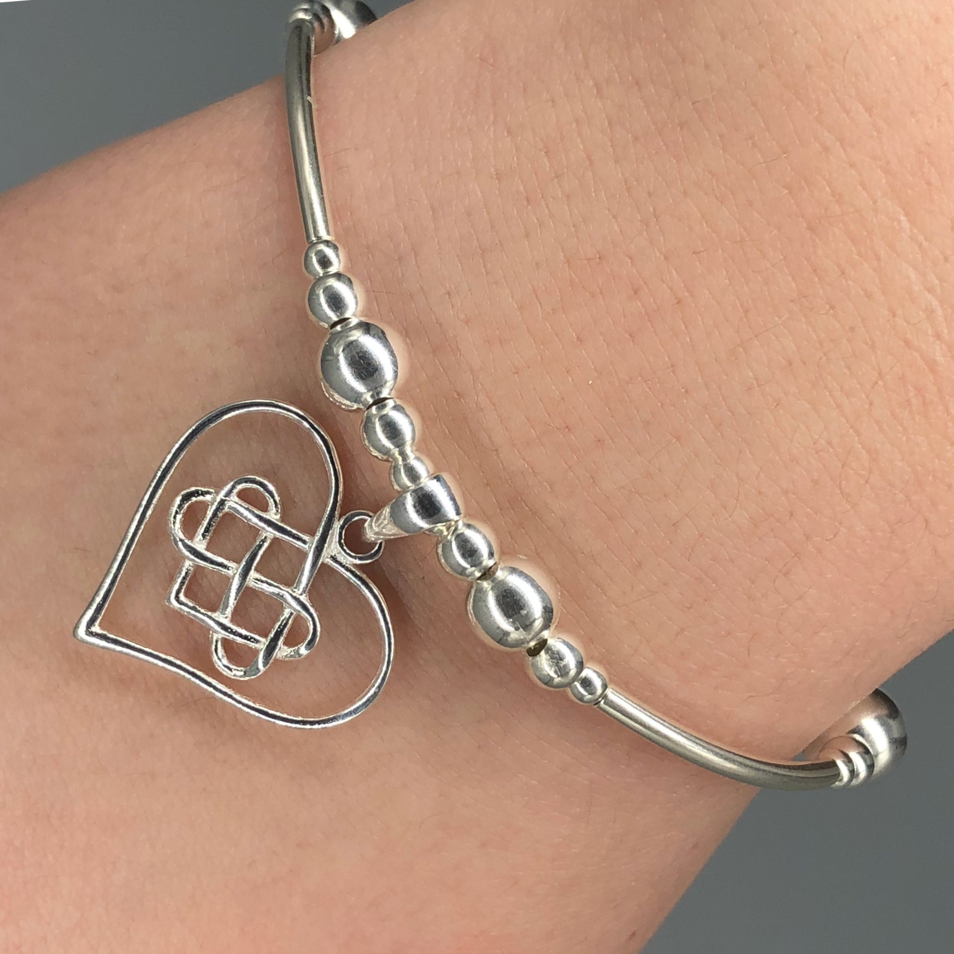 Closeup of Heart & Infinity symbol sterling silver stacking charm bracelet by My Silver Wish