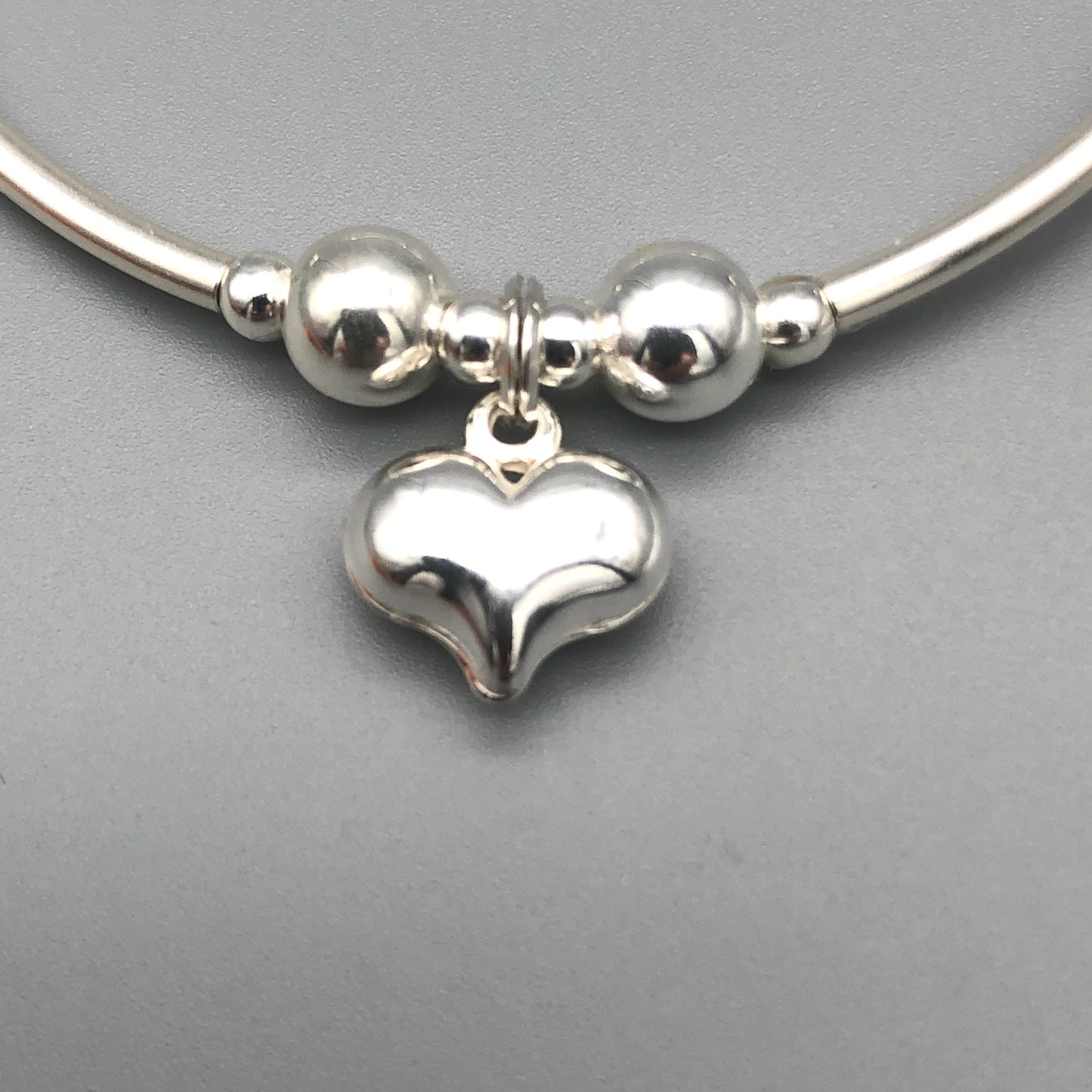 Closeup of Solid puff heart charm sterling silver stacking bracelet by My Silver Wish