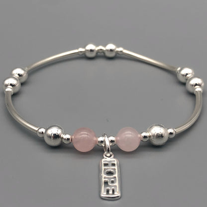 Closeup of "Hope" rose quartz healing crystal women's silver stacking charm bracelet by My Silver Wish