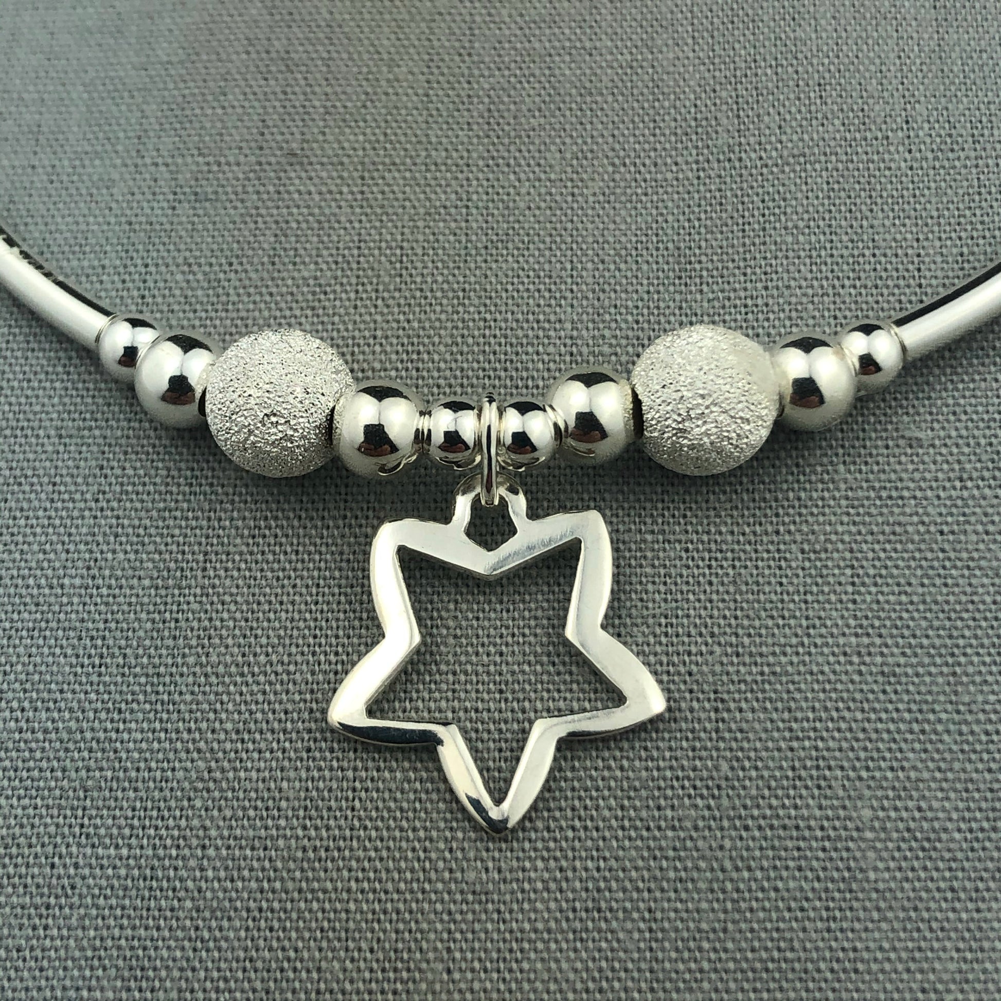 Closeup of Open star charm women's sterling silver stacking charm bracelet by My Silver Wish