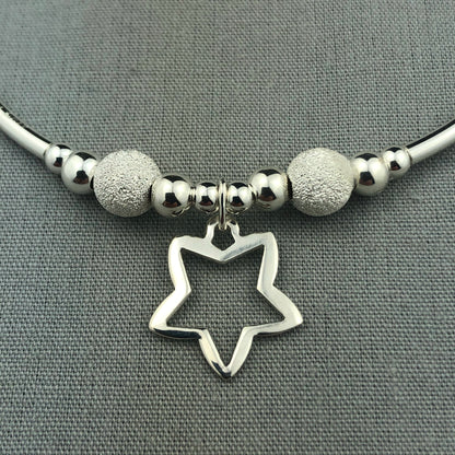 Closeup of Open star charm women's sterling silver stacking charm bracelet by My Silver Wish