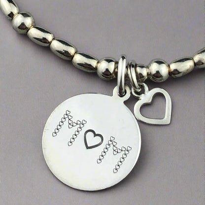 Closeup of "Mum" sterling silver hand-made women's stacking charm bracelet by My Silver Wish